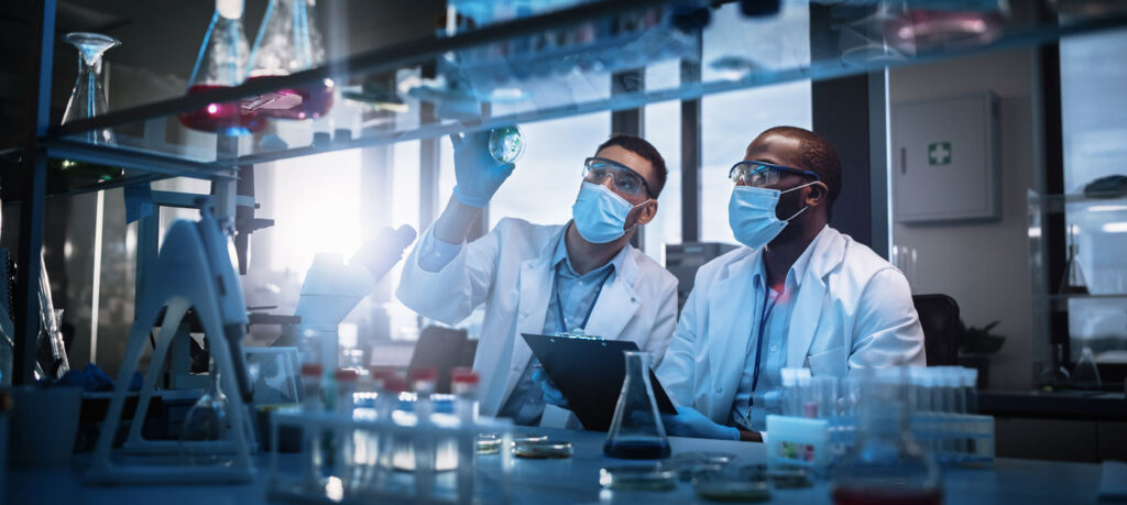 two scientists examine a petri dish in a lab